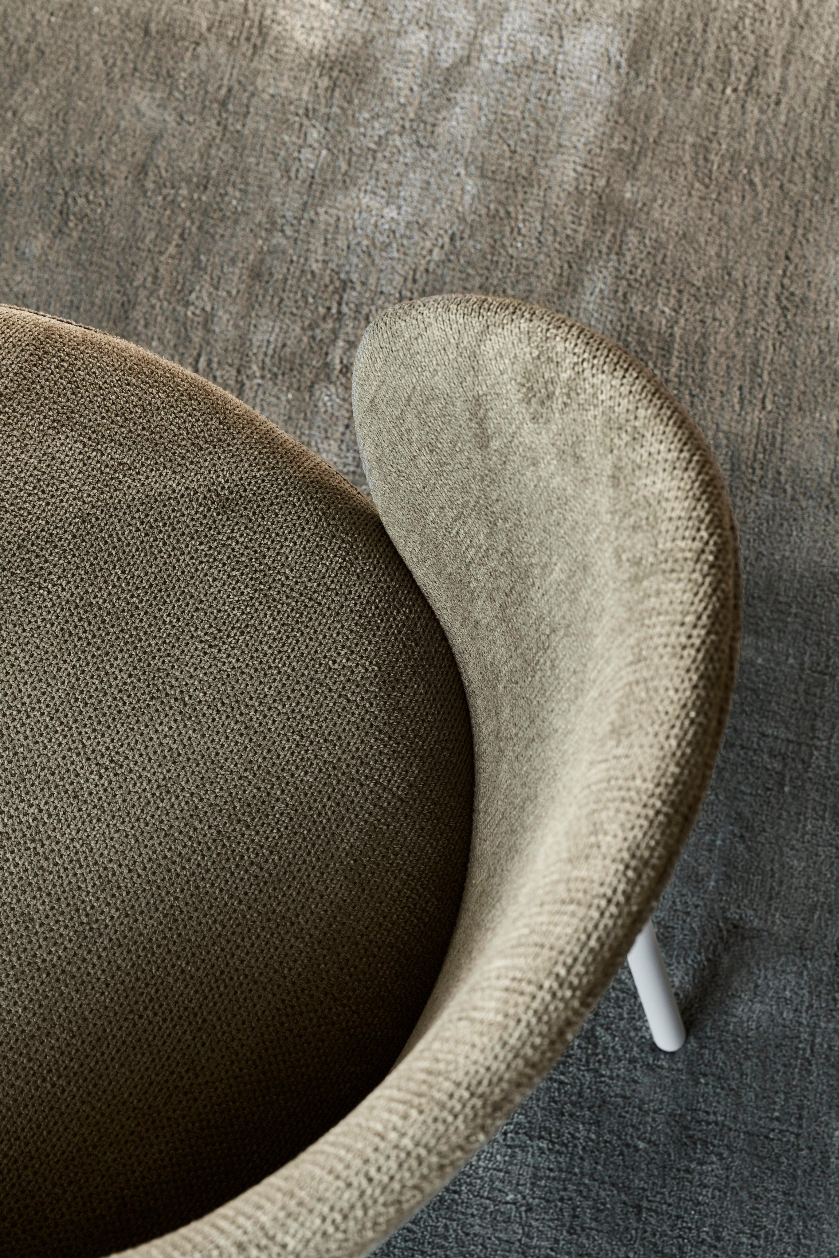 A close-up view of the Princeton chair upholstered in green Bresso fabric.