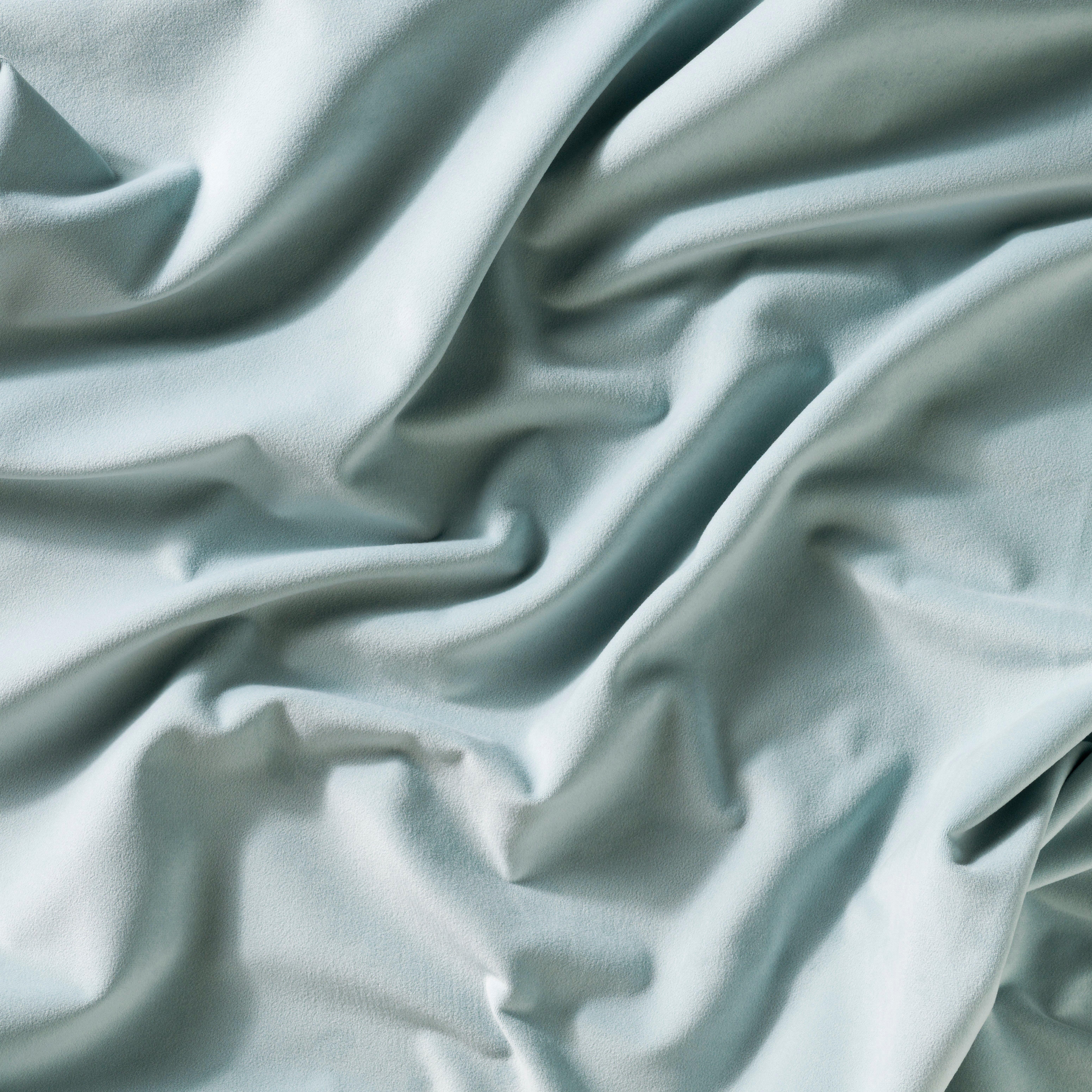 Wrinkled light blue fabric with a soft texture.