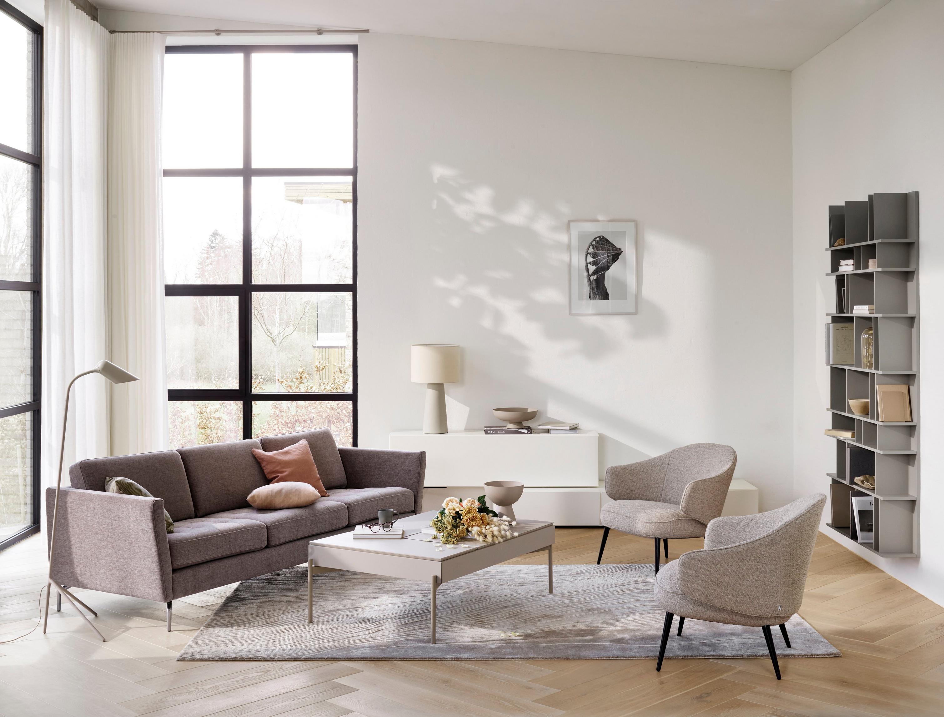 Osaka sofa with its tufted seats in a gray Tomelilla fabric with the Chiva coffee table with storage.