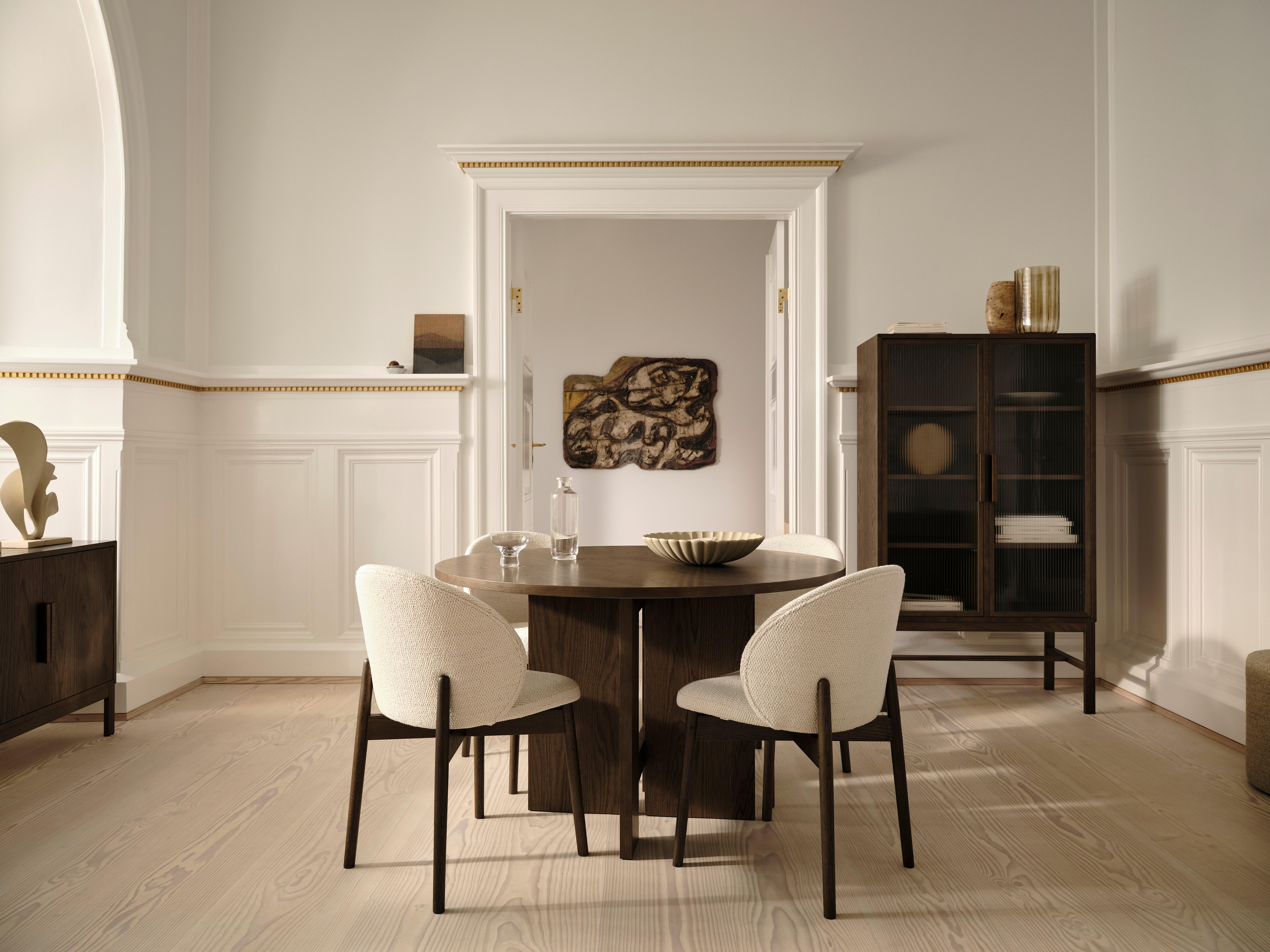 シンプルな白い椅子2脚と丸いテーブルがあるエレガントなダイニングルーム。