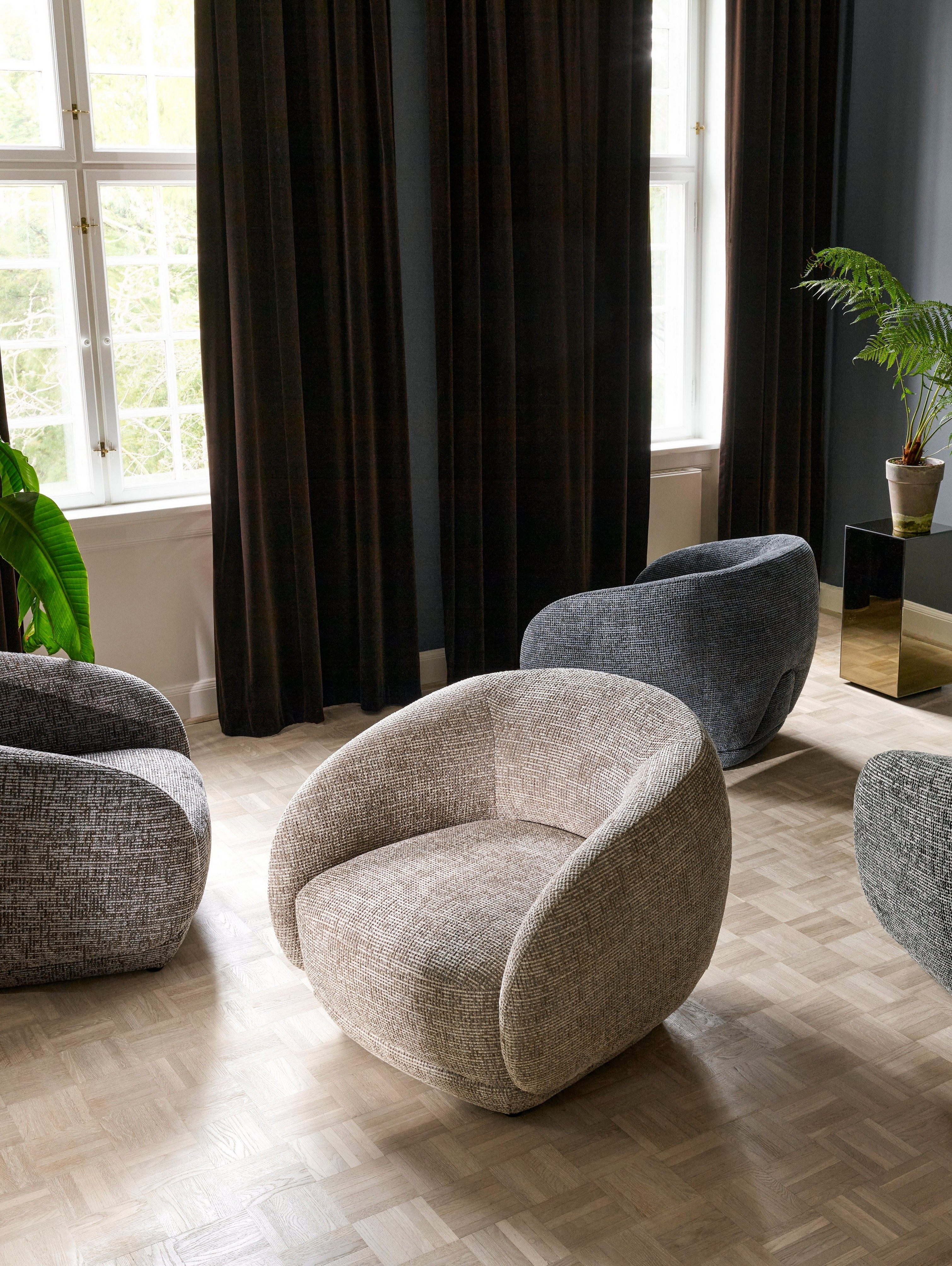 Quatro cadeiras Bolzano numa sala de estar colocadas em direções aleatórias.