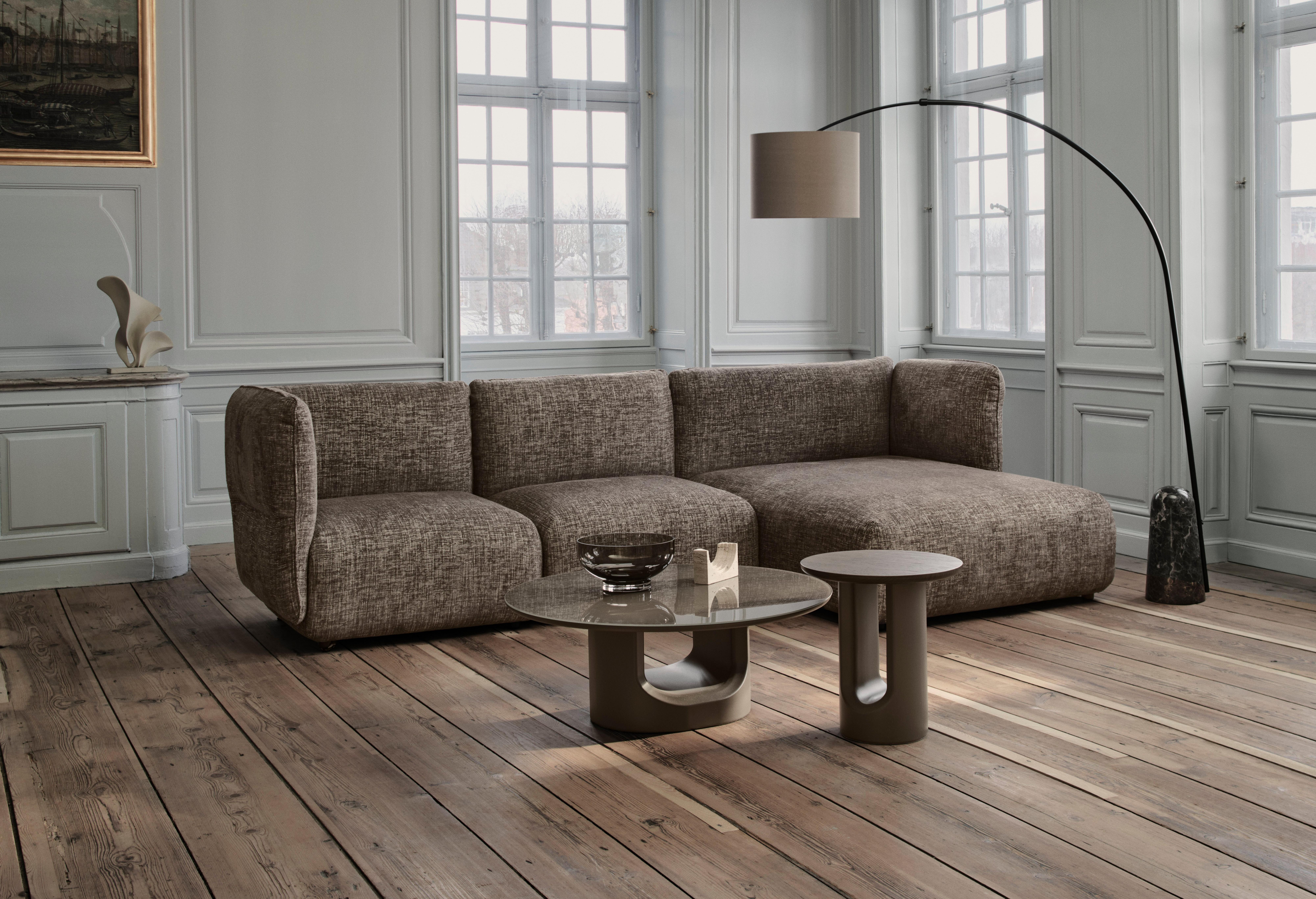 Textured corner sofa with chaise, glass coffee table and arched floor lamp.