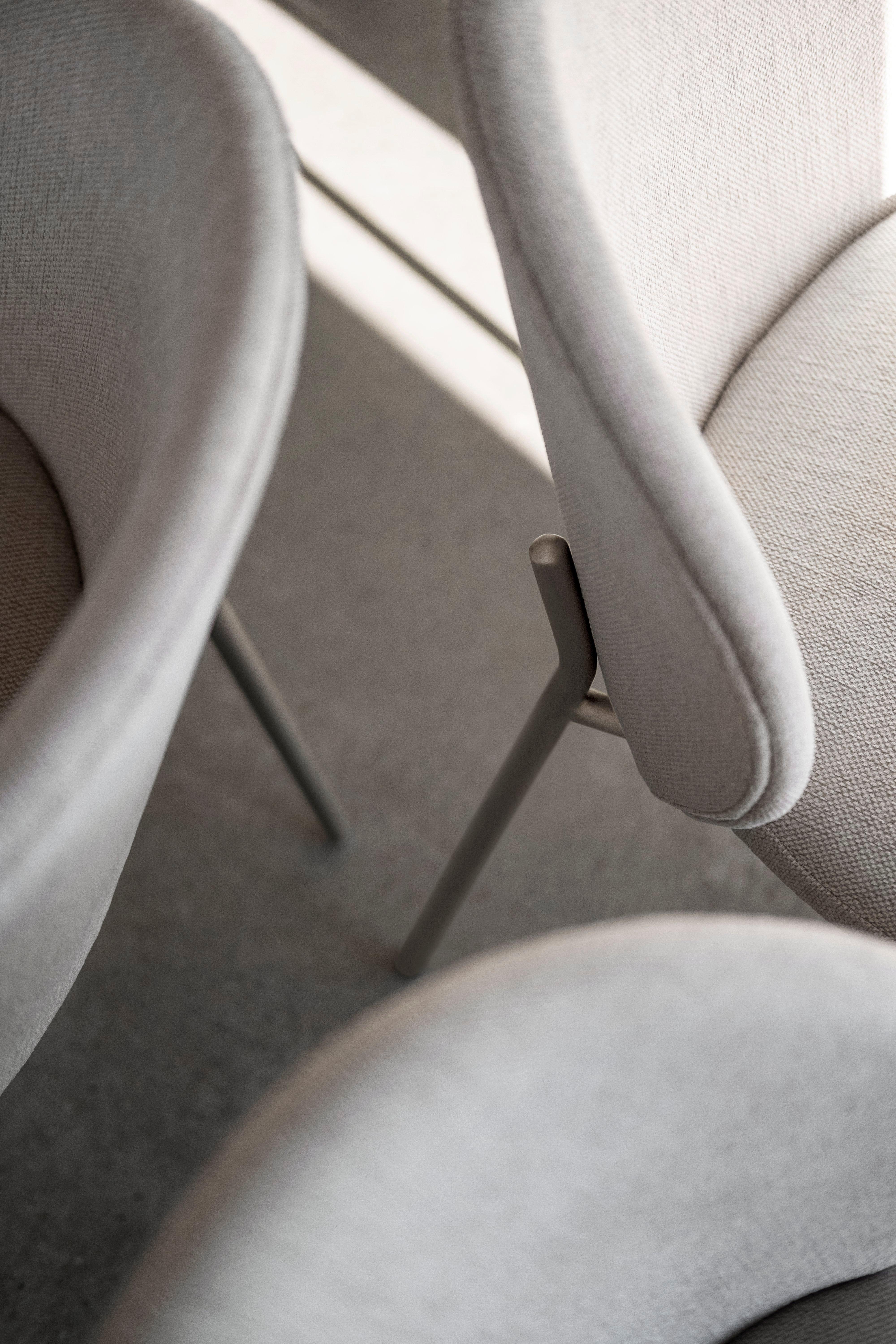 Close-up of light grey fabric chairs with a focus on the texture and elegant design details.