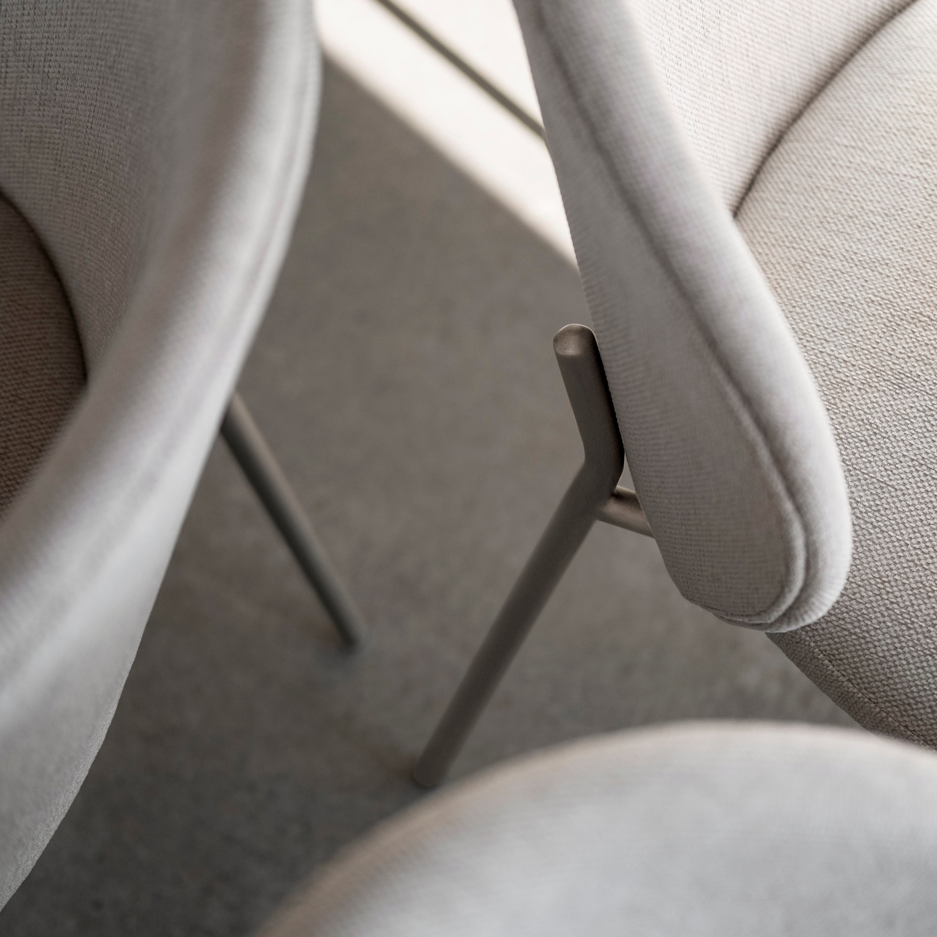 Close-up of light grey fabric chairs with a focus on the texture and elegant design details.