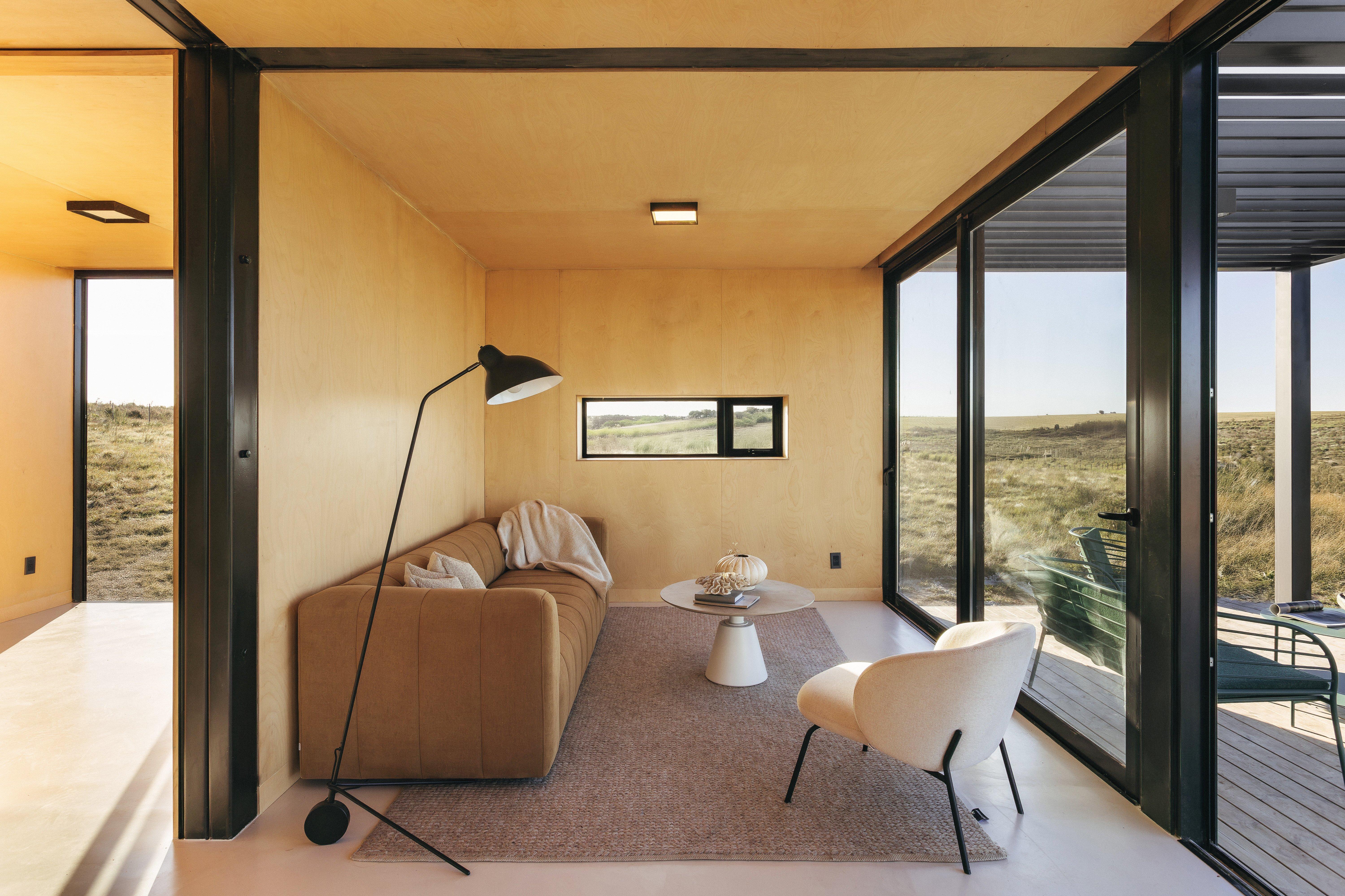 現代客廳，棕色沙發，落地燈，白色椅子和圓桌，窗外景色。