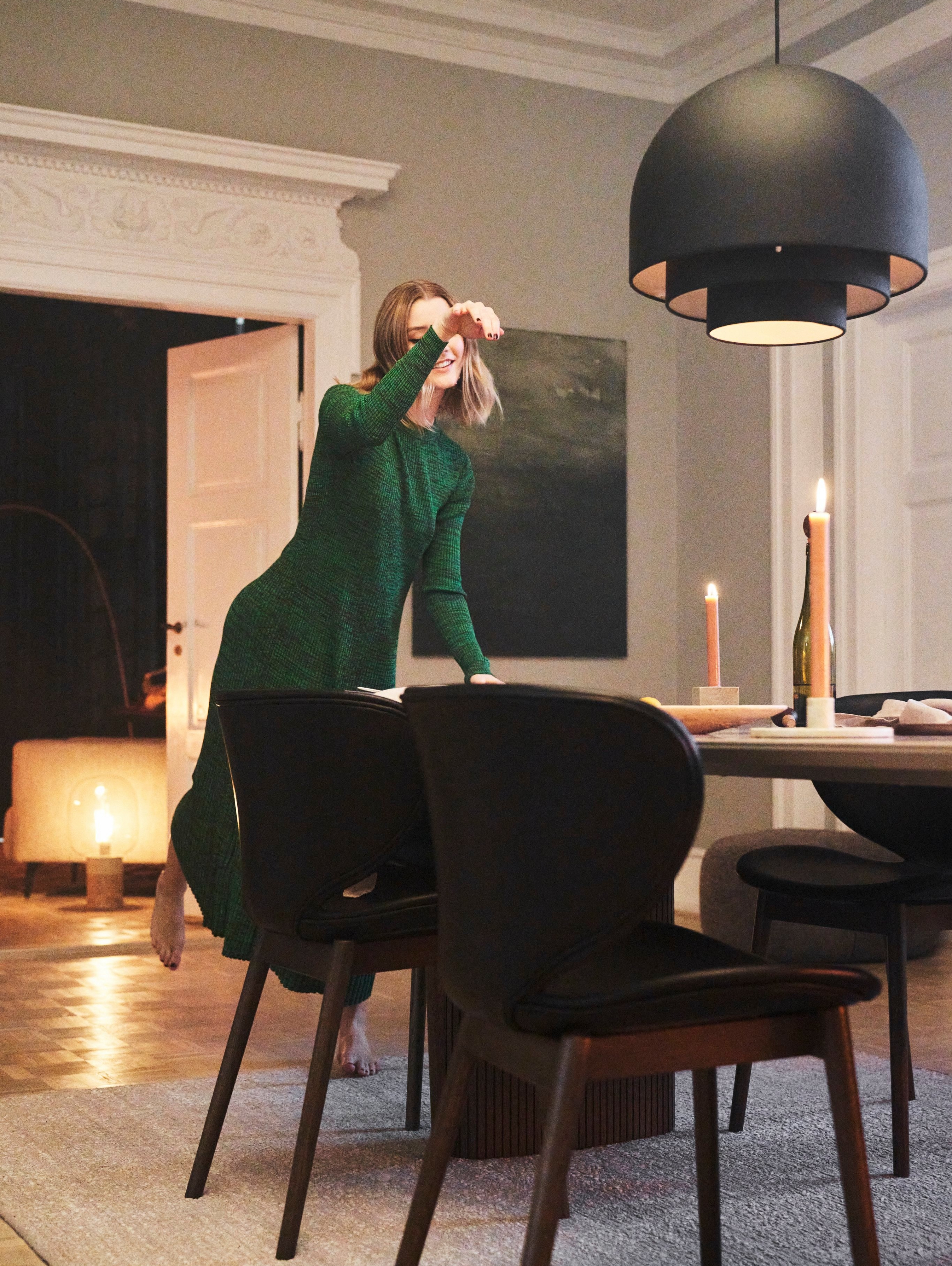 A woman dancing next to the Santiago dining table in brown ceramic
