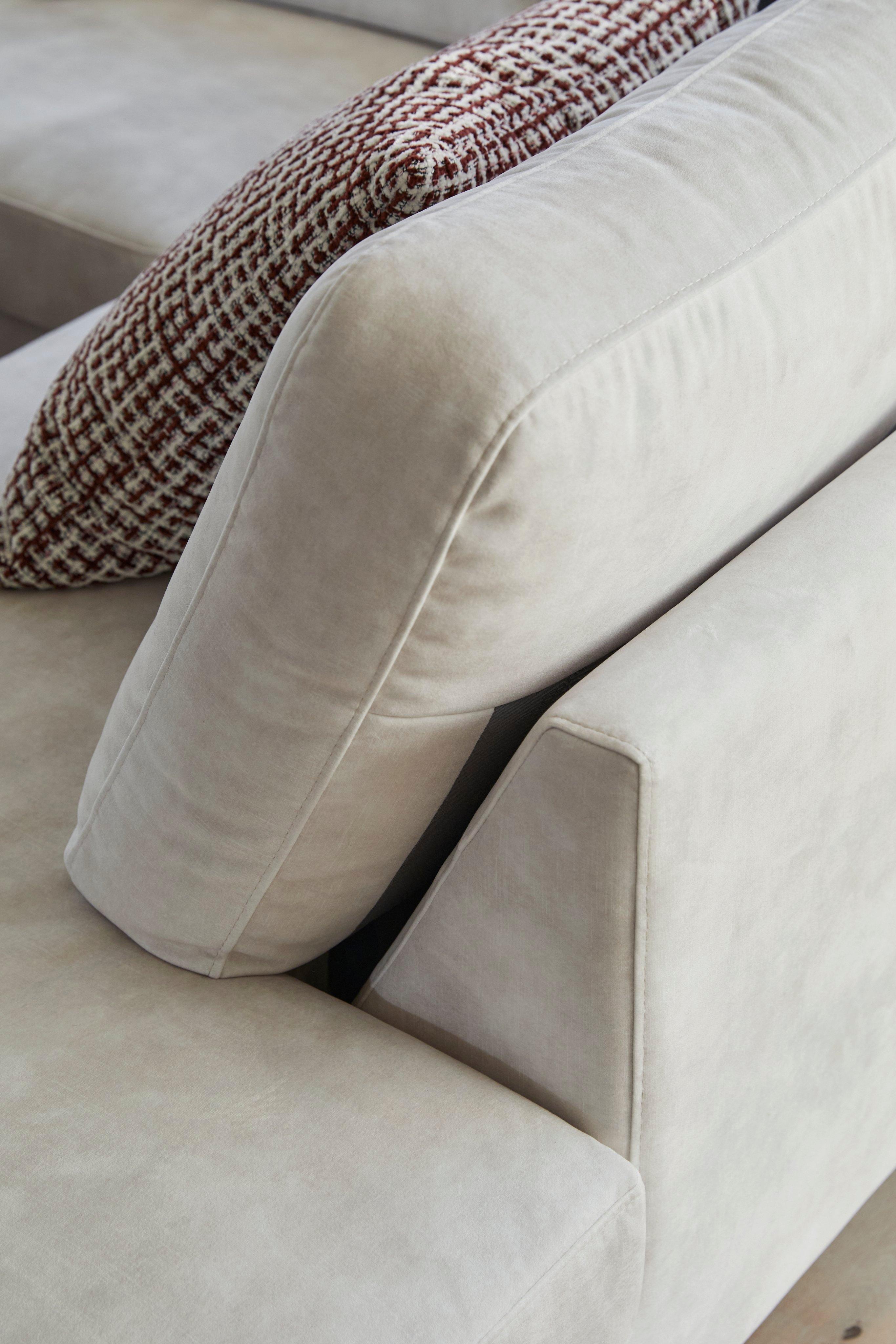Beige sofa with a textured cushion in red and white pattern on the seat.