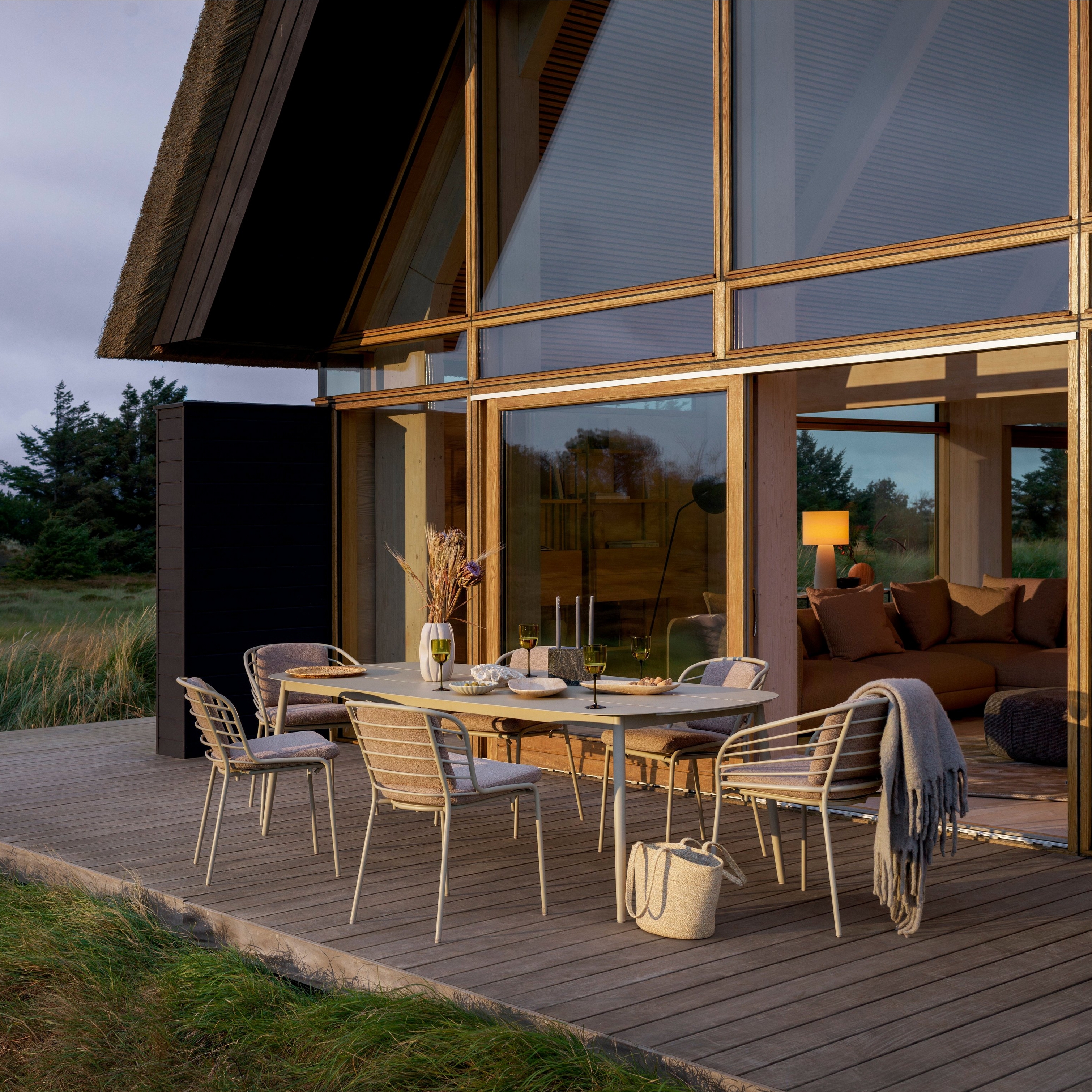 Open-air dining space at dusk featuring the Cancún dining table and dining chairs in matt ash grey.