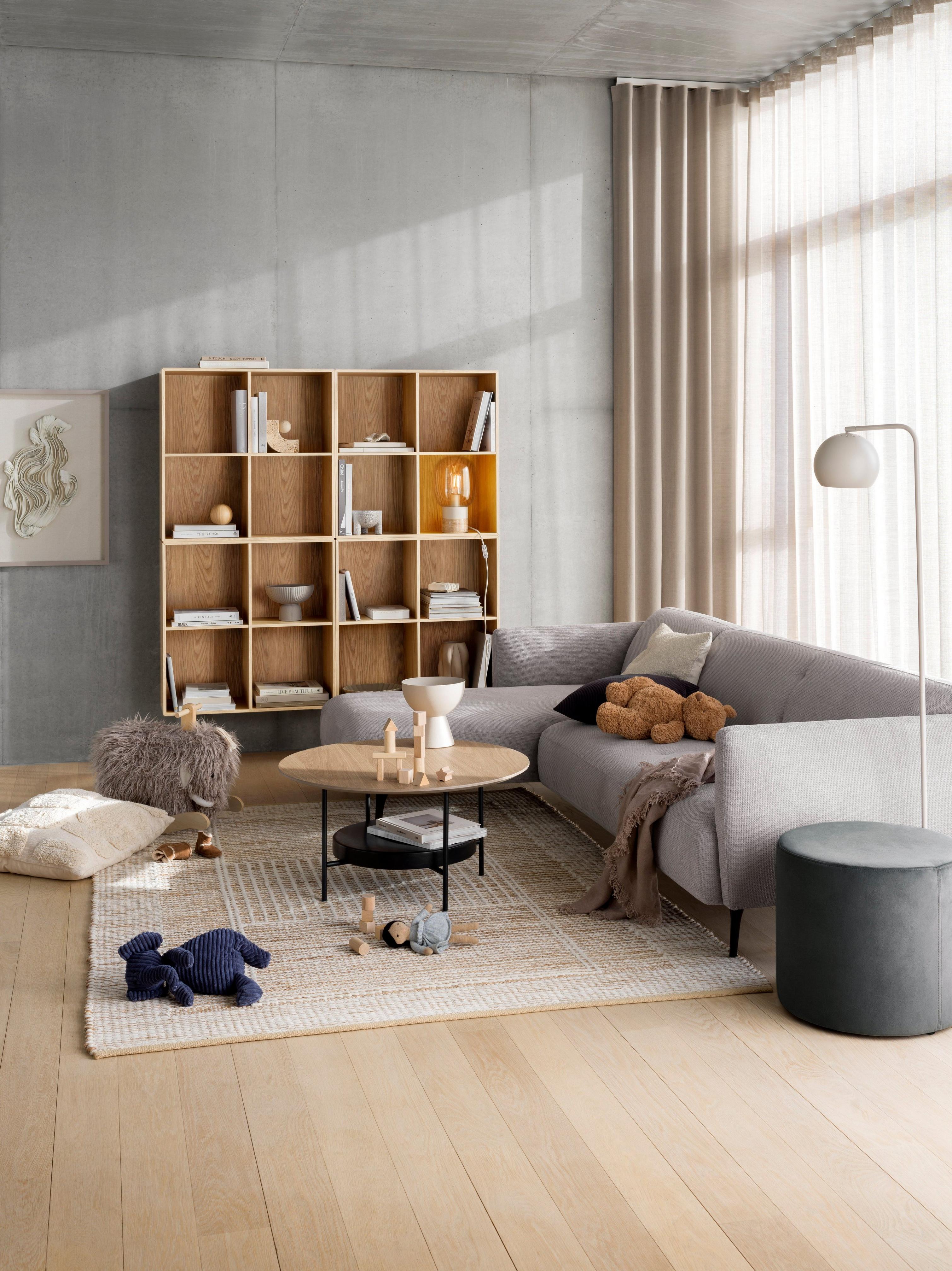 Sofa Moderna z szezlongiem ustawiona w pokoju ze stolikiem kawowym Madrid i półką na książki Como.