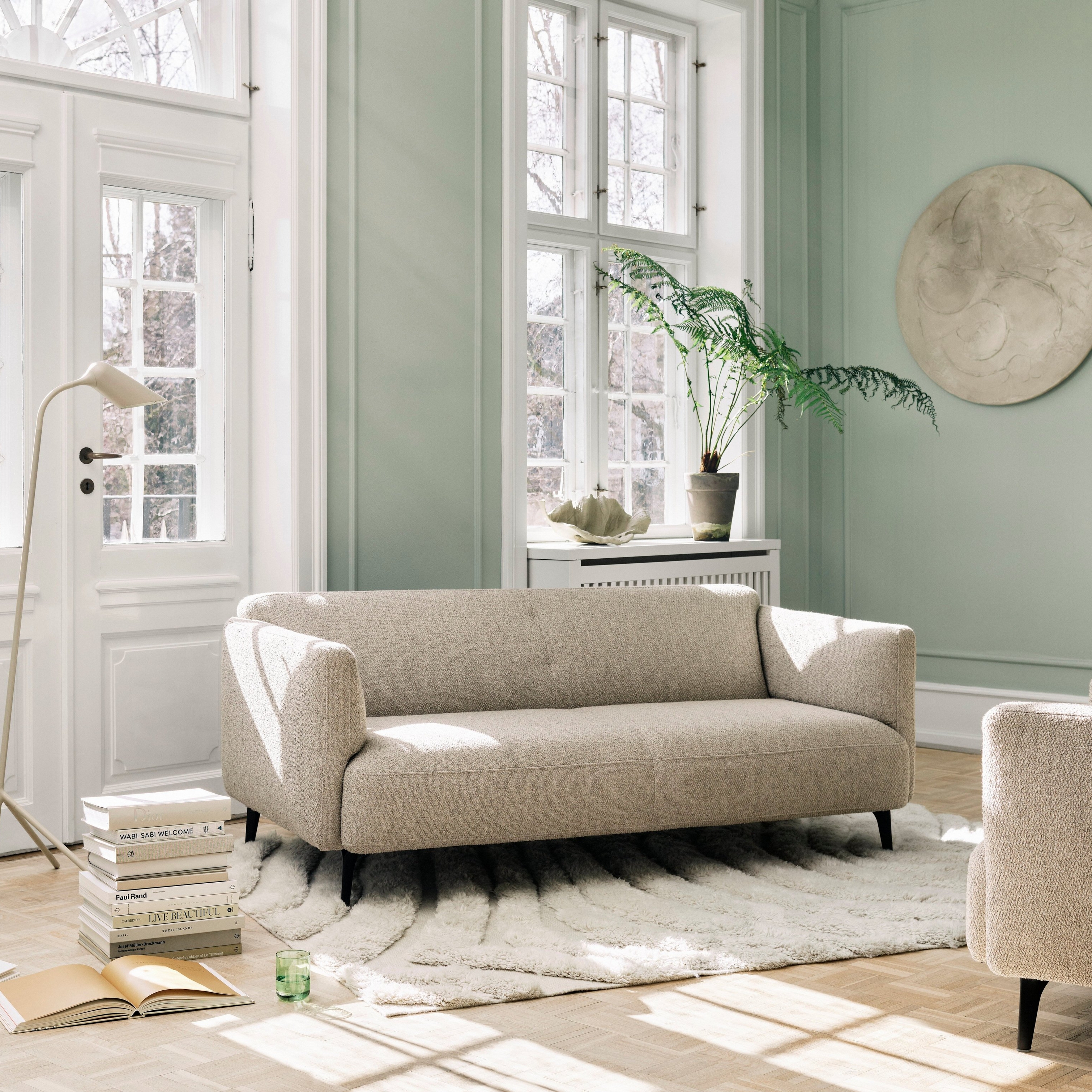 Modernt och neutralt vardagsrum med Modena soffa och Curious golvlampa.