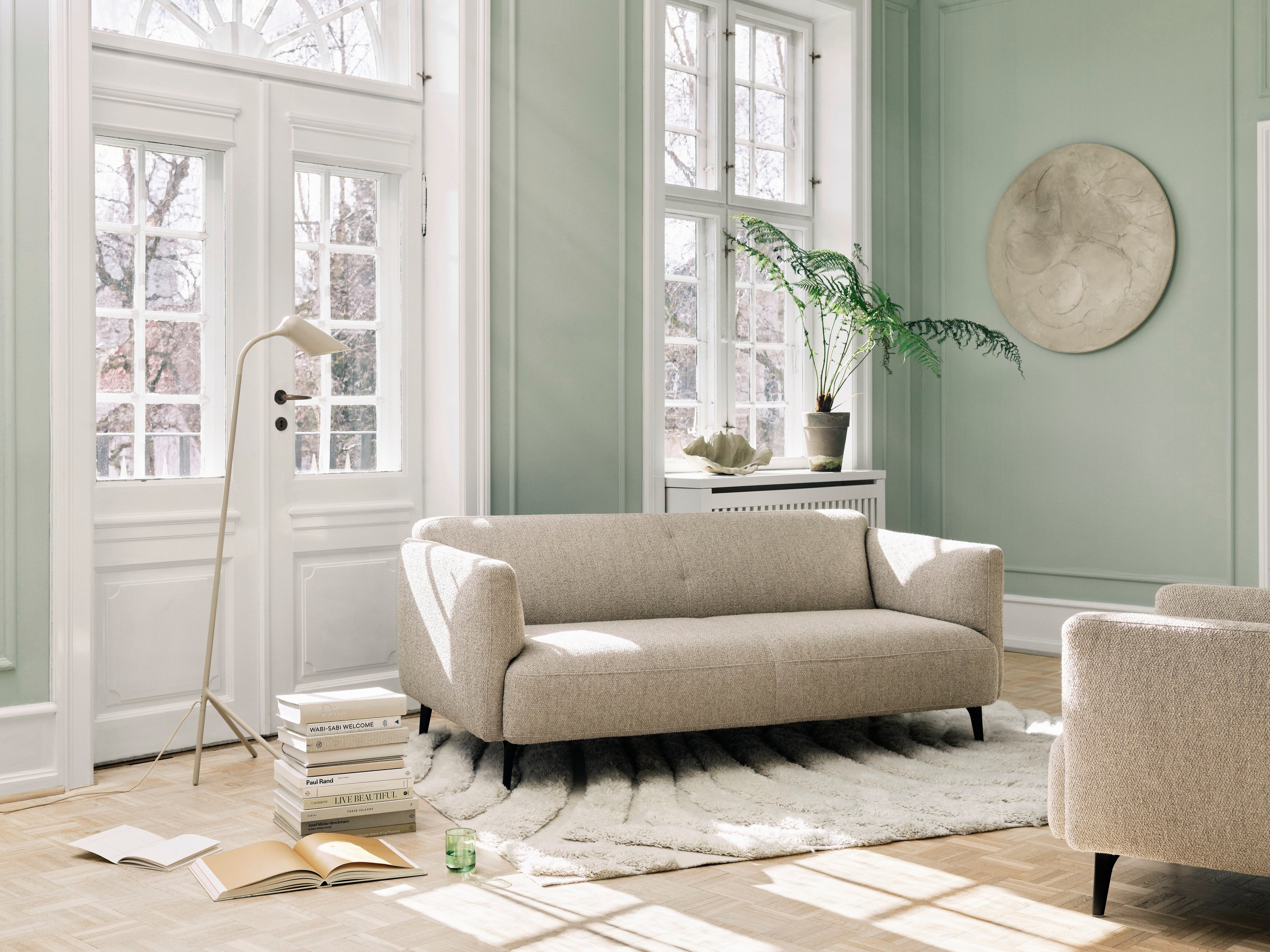 Modern neutral living space featuring the Modena sofa and the Curious floor lamp.