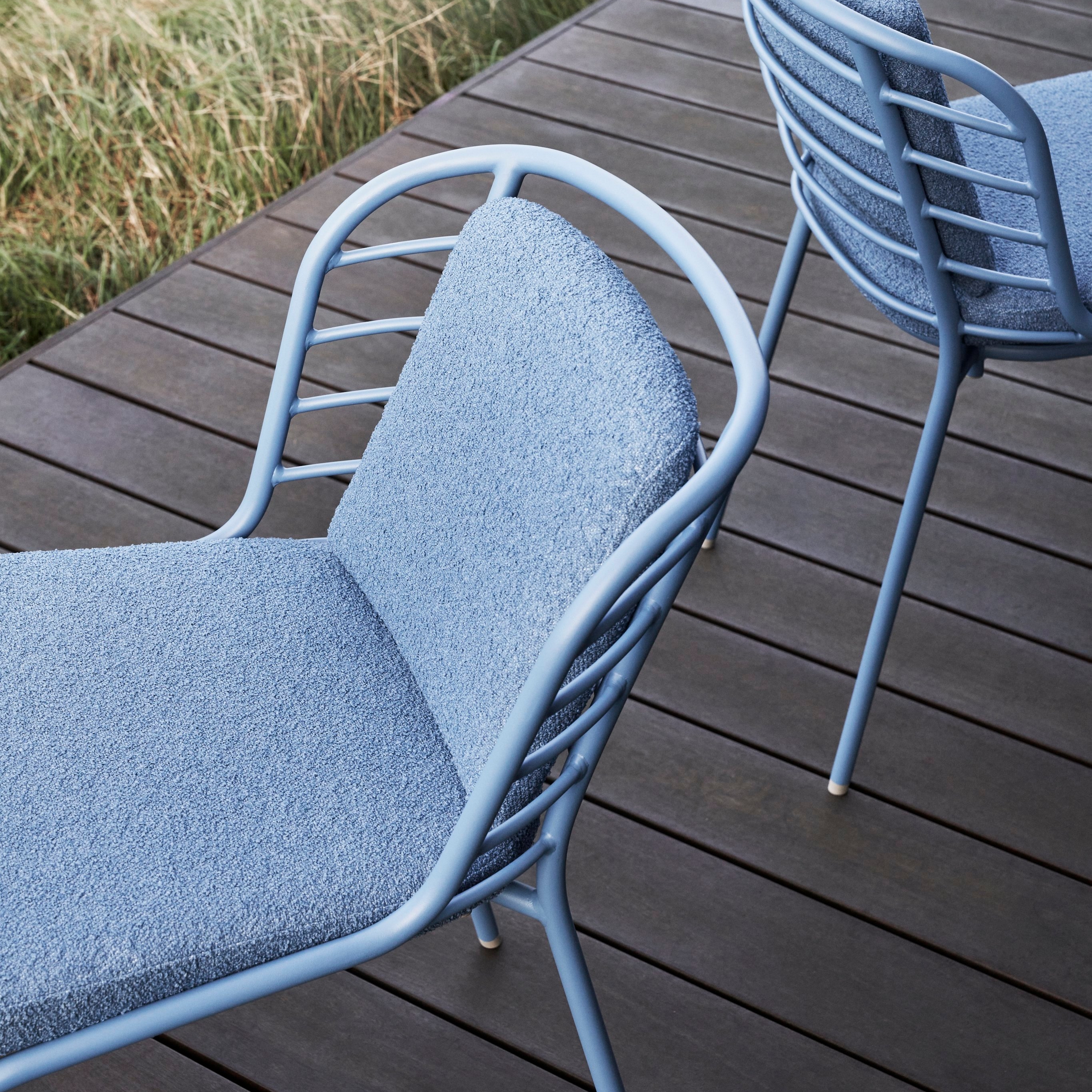 An outdoor deck with two Cancún dining chairs in Matt Blue with matching cushions.