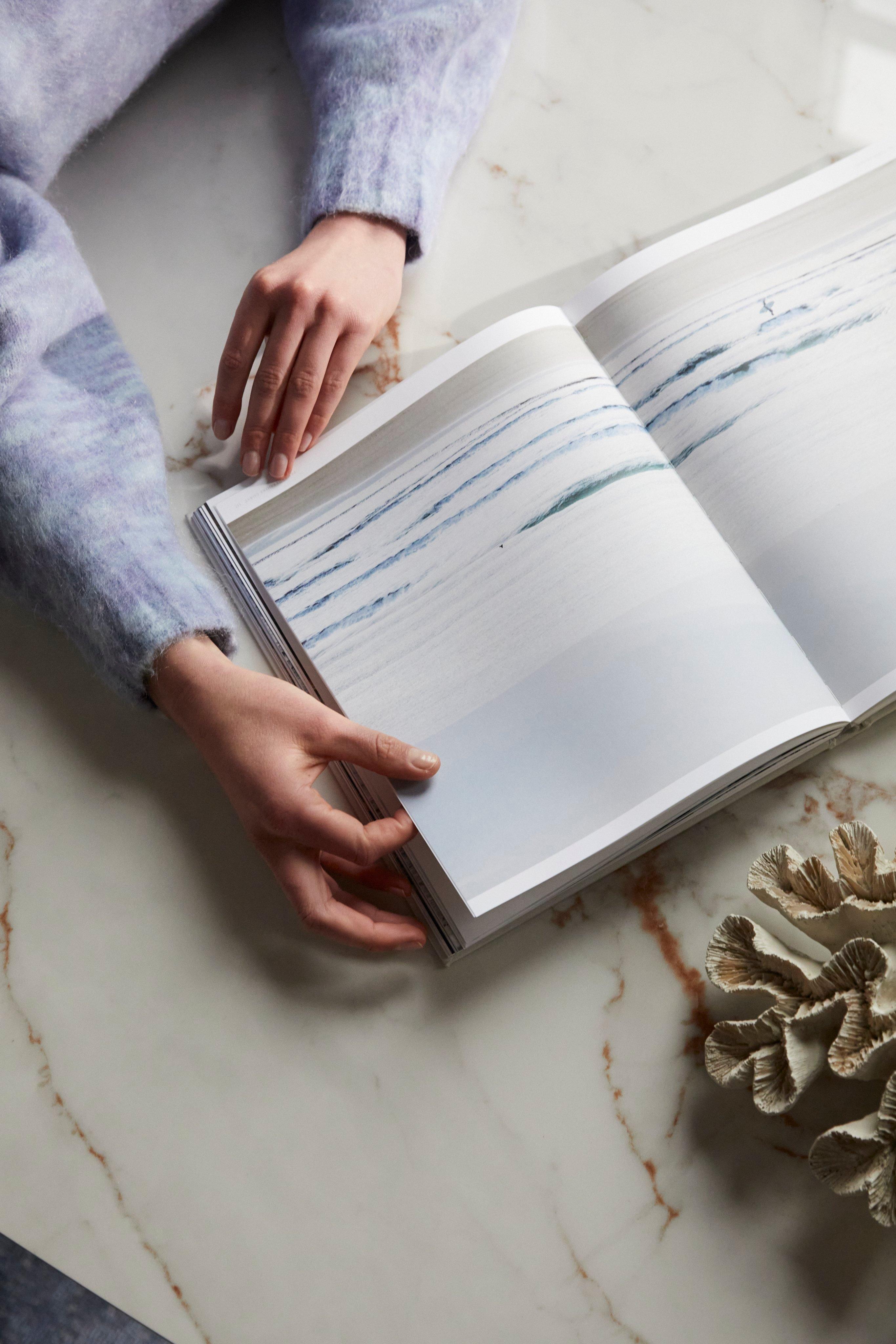 双手摊开一本书，旁边有一个装饰物。