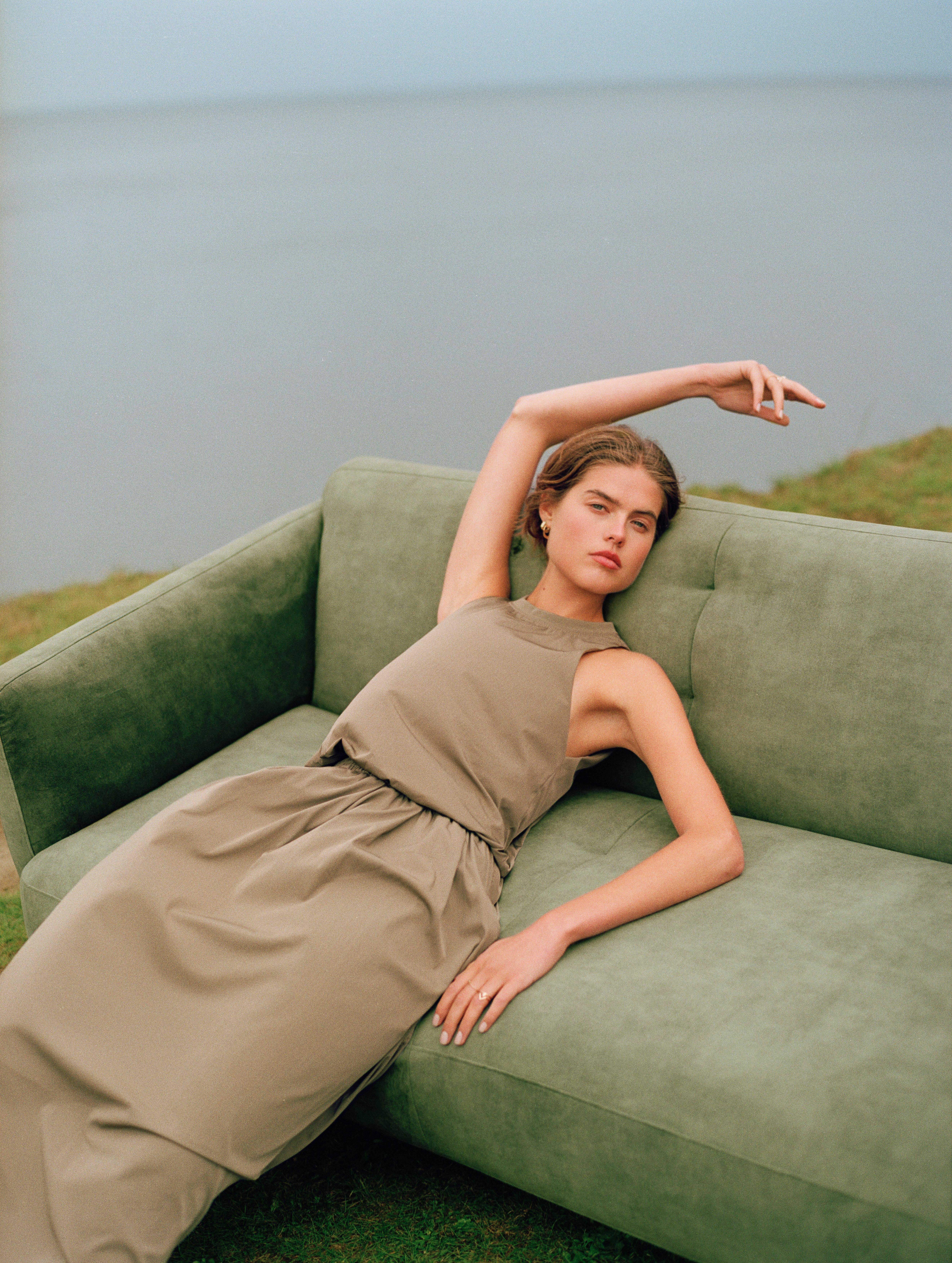 Mujer descansando en el sofá Modena en una sala llena de luz.