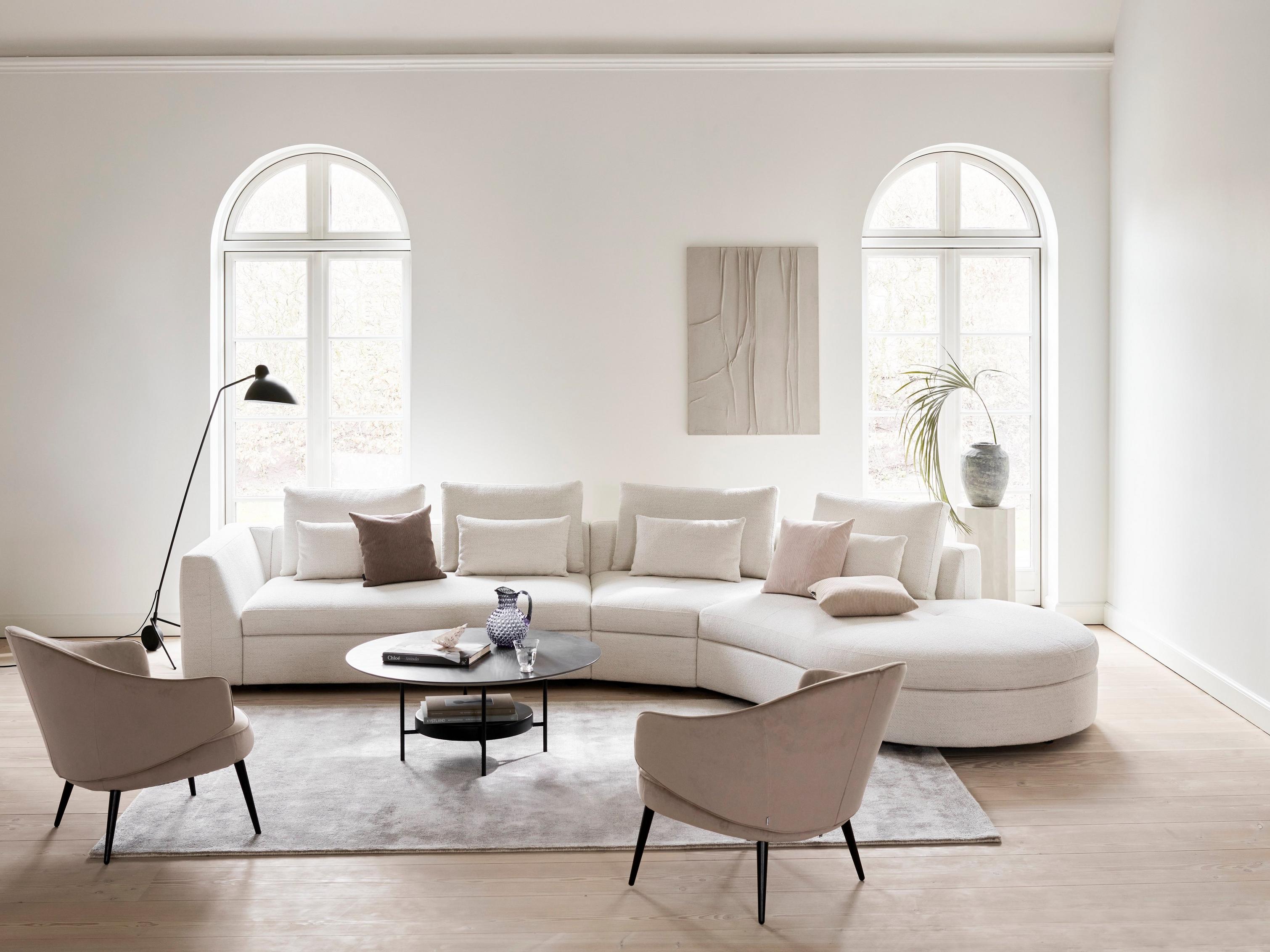 O sofá Bergamo com módulo relax redondo em tecido Lazio, com a mesa de apoio Madrid com revestimento de cerâmica em mármore escuro.