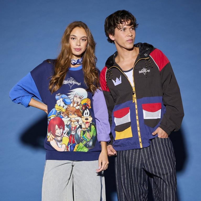 Two models wearing Disney graphic sweatshirt and color-block zip jacket. Shop Now.