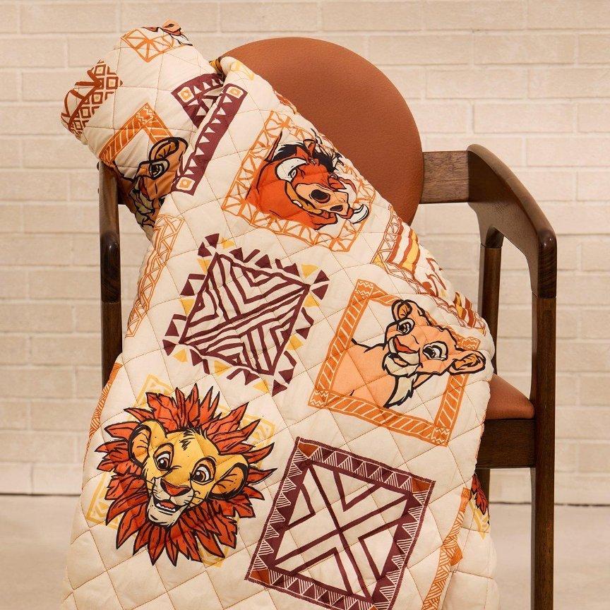 Disney Lion King patterned quilt throw draped over a wooden chair. Shop Now.