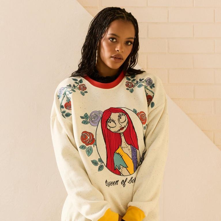 Model wearing a sweatshirt with floral print and Sally character graphic on the front and “Queen of Scream” text. Shop Now.