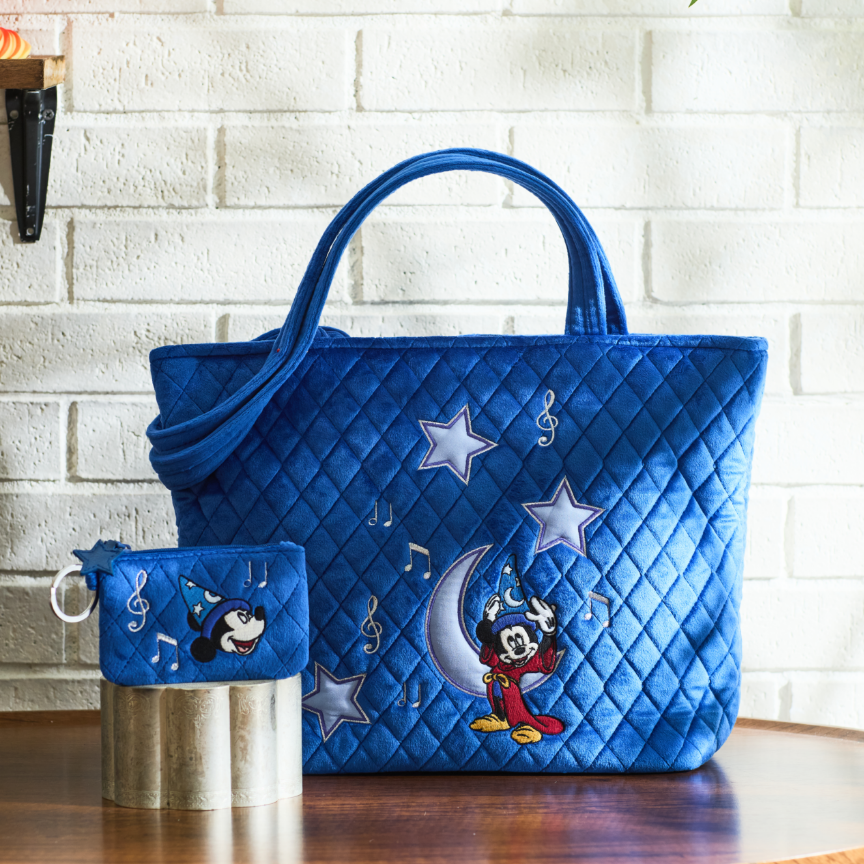 Blue quilted tote bag and matching pouch with Sorcerer Mickey, stars, and music notes. Shop Now.