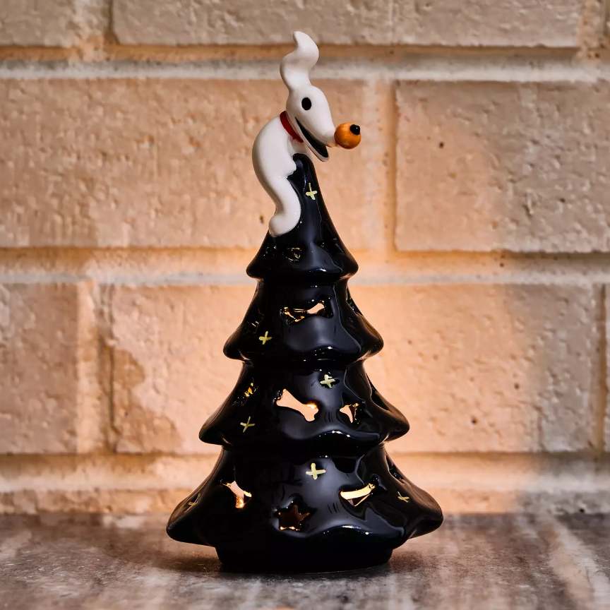 Black ceramic Nightmare Before Christmas tree with star cutouts and Zero as the topper. Shop Now.