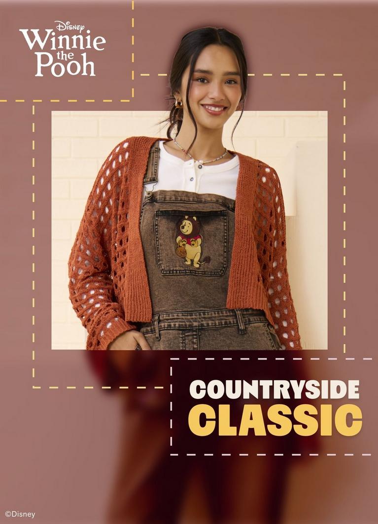 Model wearing Disney Winnie the Pooh denim overalls. Shop Now.