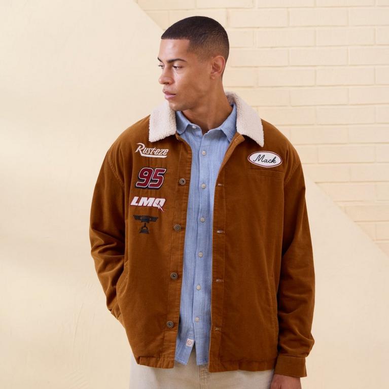  Model wearing a brown sherpa-collar jacket with Mack, Rust-eze, 95, and LMQ patches. Shop Now.