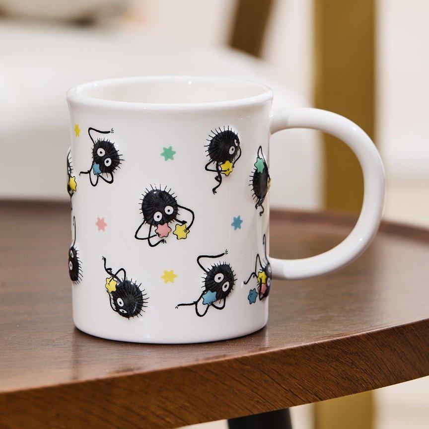 White mug with soot sprites and colorful star print. Shop Now.
