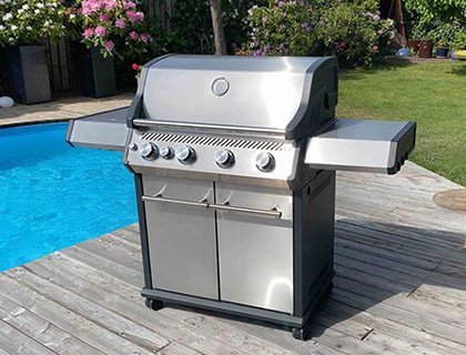 En gasolgrill som ståendes på trall bredvid en pool