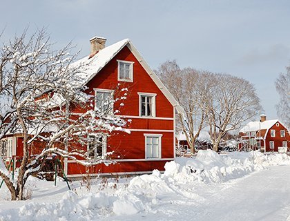 Ett stort rött trähus i ett vinterlandskap