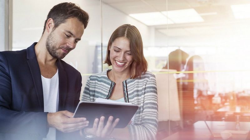 Business people smiling at tablet