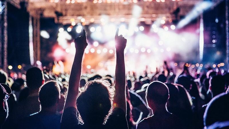 Man at a concert with his arms in the air