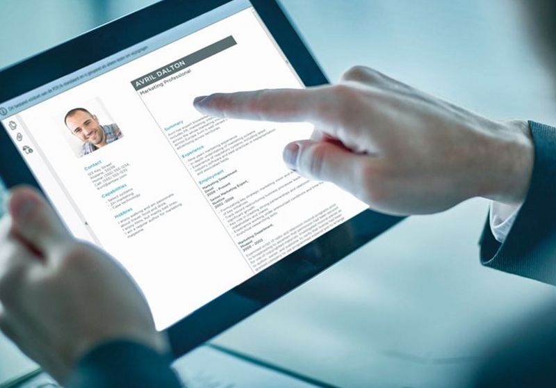 Man holding an iPad whilst pointing at something on the screen