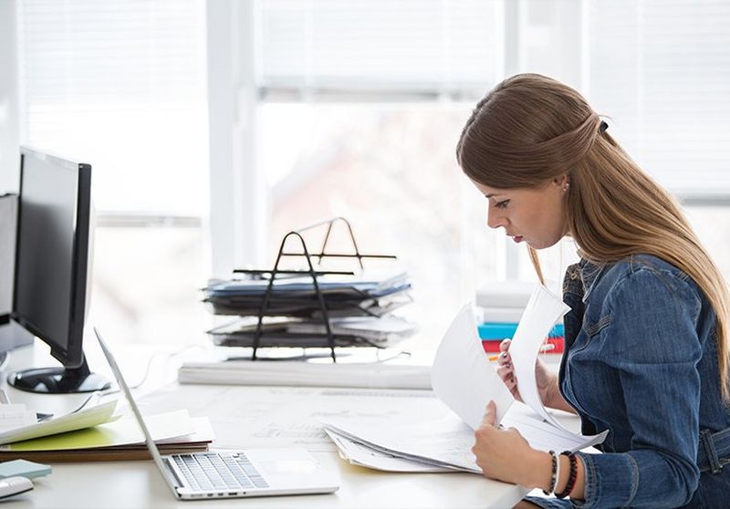 Woman looking through pile of papers