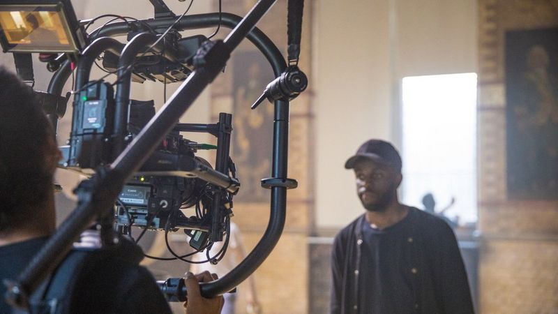 Man being filmed with  Canon video camera