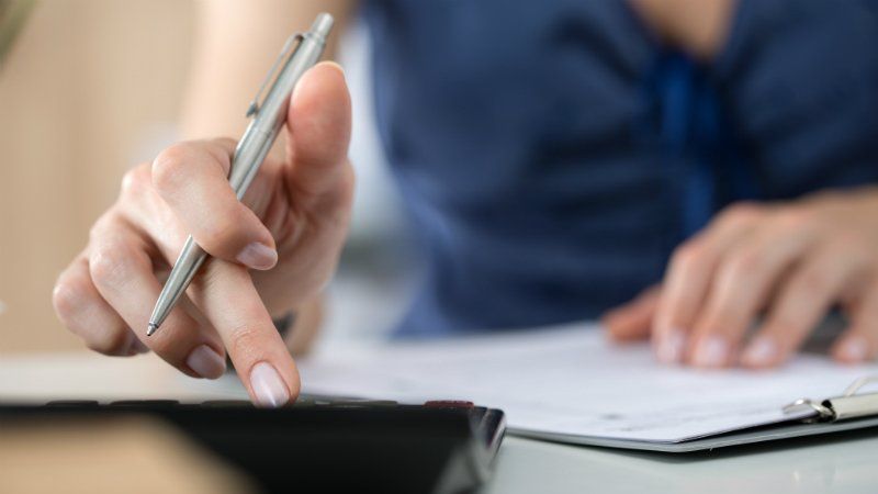 Purchase to Pay - Close up of female hands pressing calculator
