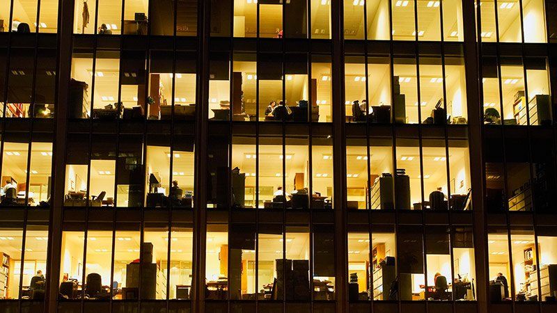 Outside large office building with lights on