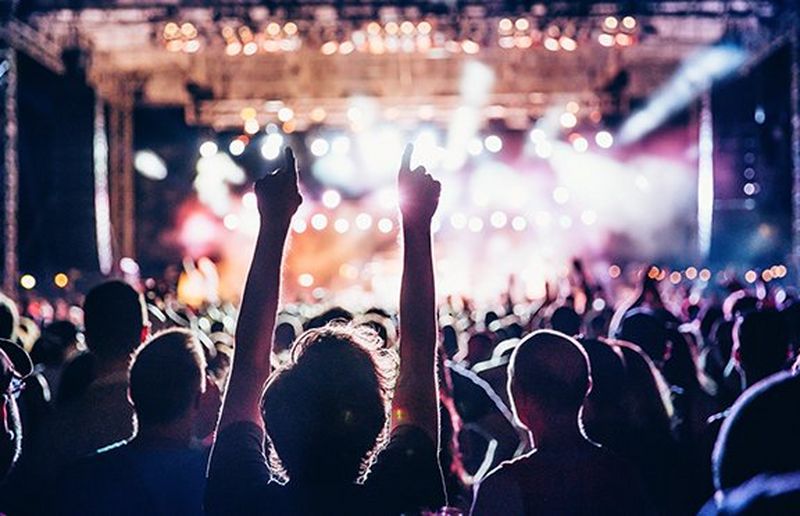 Man at a concert with his arms in the air