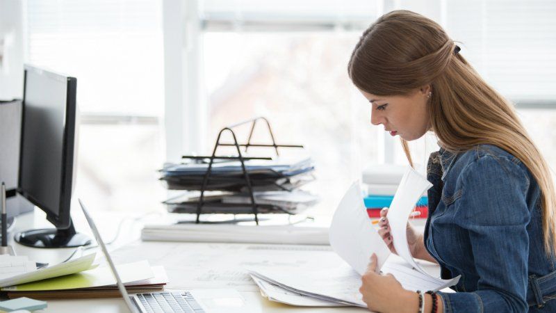 Invoice processing -girl at work desk looking over files