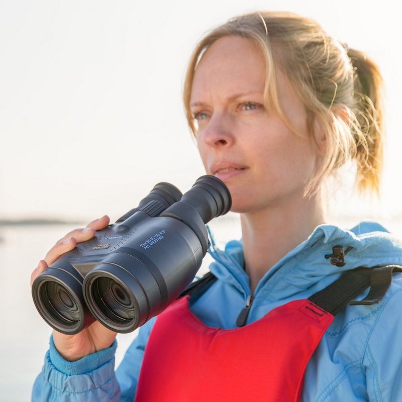 Canon 15x50 IS AW Allwetter-Fernglas Frau, die das Fernglas an ihre Augen hält