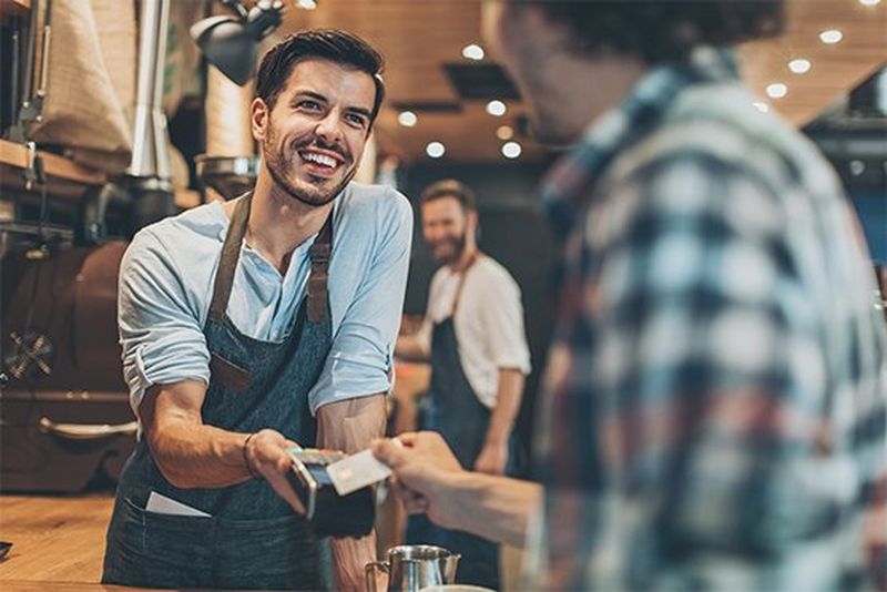 Man pays by card in coffee shop