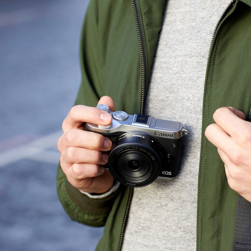 Canon EOS M6 + EF-M 15-45mm IS STM Objektiv – Silber 0 Ein Mann, der die Kamera hält