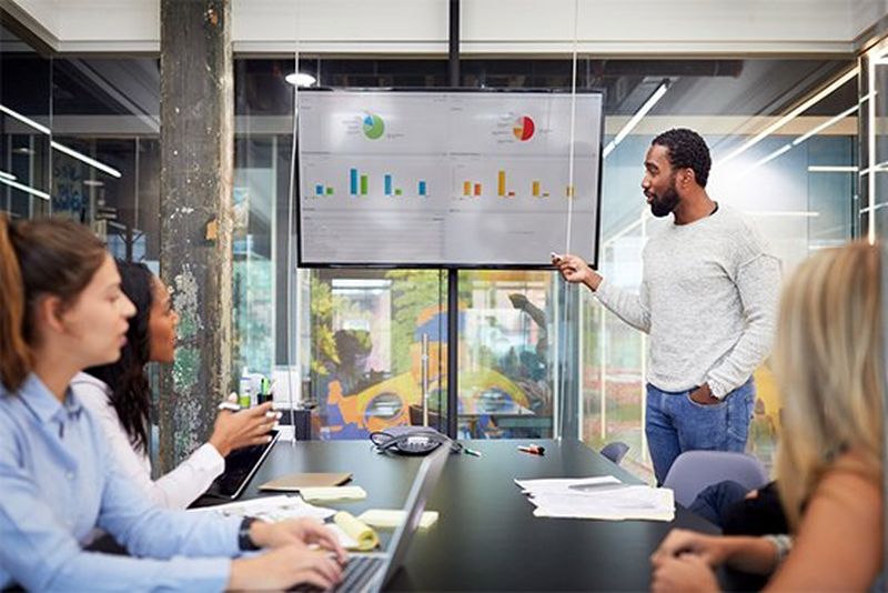 Man presents graphs at a meeting