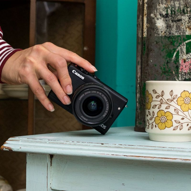 Canon EOS M100 Schwarz + Canon EF-M 15-45mm f/3.5-6.3 IS STM Objektiv Schwarz 0 Die Kamera auf einem Regal