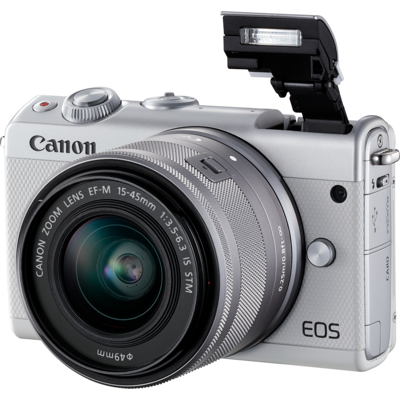 Canon EOS M100 Weiß + EF-M 15-45mm f/3.5-6.3 IS STM Objektiv Silber Produkt Diagonale Ansicht mit internem Blitz
