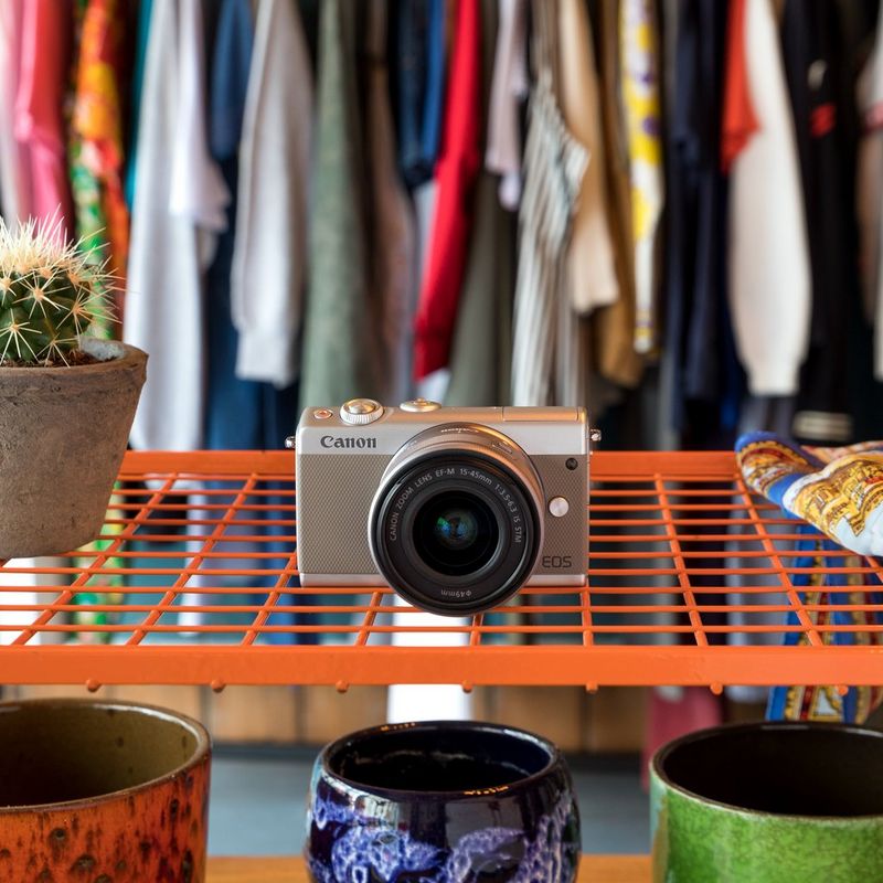 Canon EOS M100 Grau + EF-M 15-45mm f/3.5-6.3 IS STM Objektiv Silber 0 Die Kamera auf einem Regal