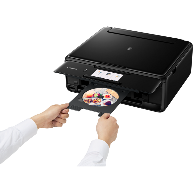 Canon PIXMA TS8150 – Schwarz Produkt Schrägansicht von vorne mit einer Person, die eine CD einsetzt