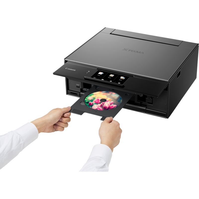 Canon PIXMA TS9150 – Dunkelgrau Produkt Schrägansicht von vorne mit einer Person, die eine CD einsetzt