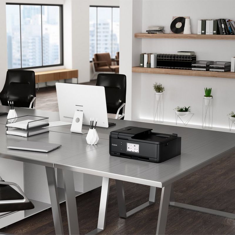 Canon PIXMA TR8550 Auf einem Bürotisch neben einem Desktopmonitor und einem Laptop