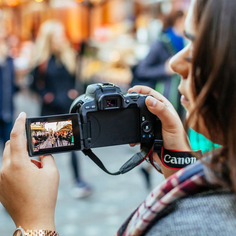 Canon EOS 200D Schwarz + EF-S 18-55mm 1:3,5-5,6 III Objektiv Frau, die eine Kamera hält, um ein Foto zu machen