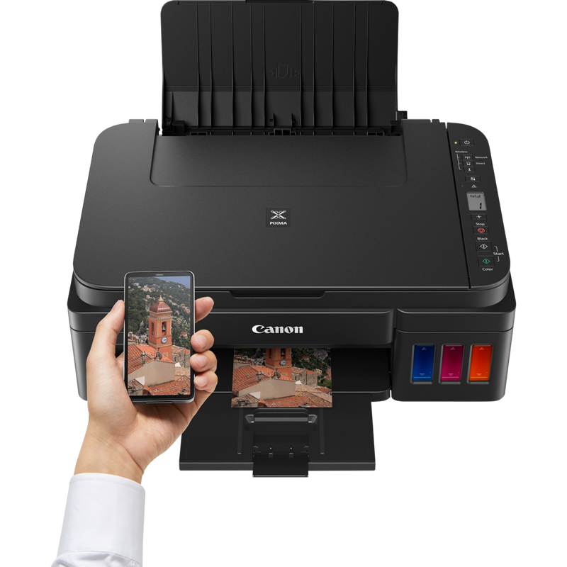 Canon PIXMA G3510 Drucker Auf einem Tisch vor einer Person, die ein Smartphone nutzt